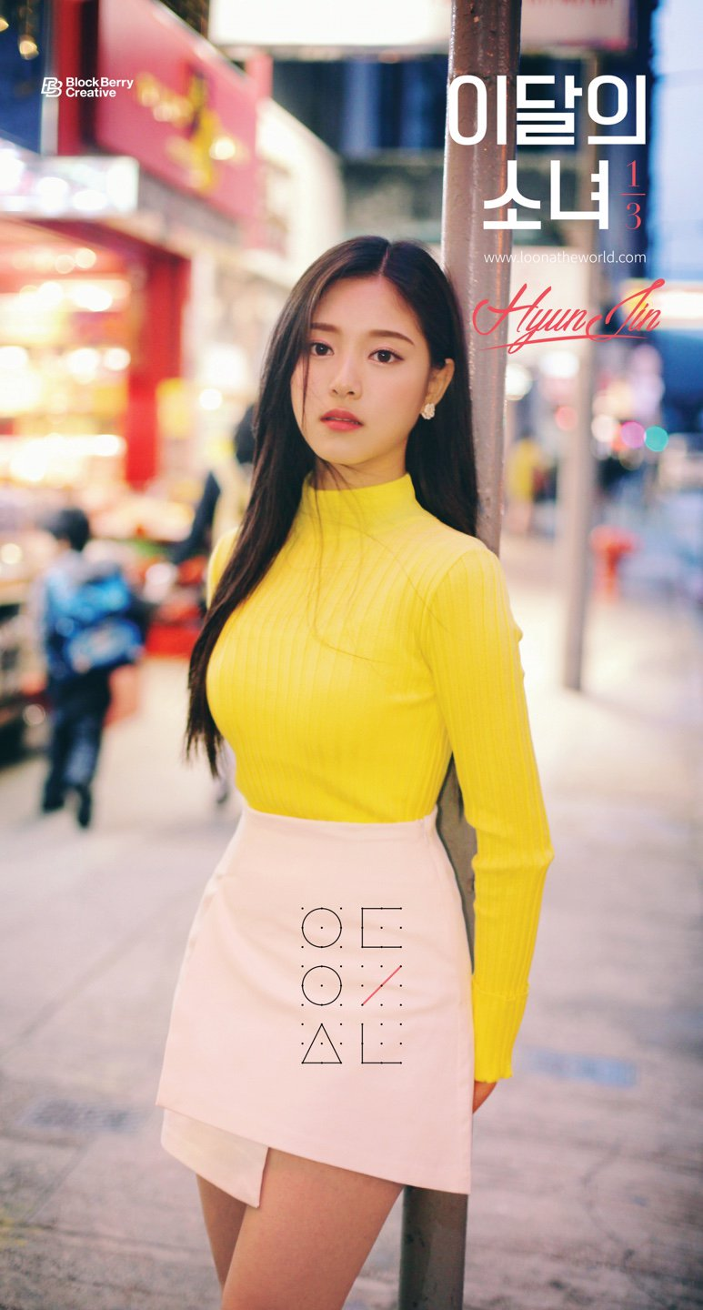 Hyunjin leaning against a pole.